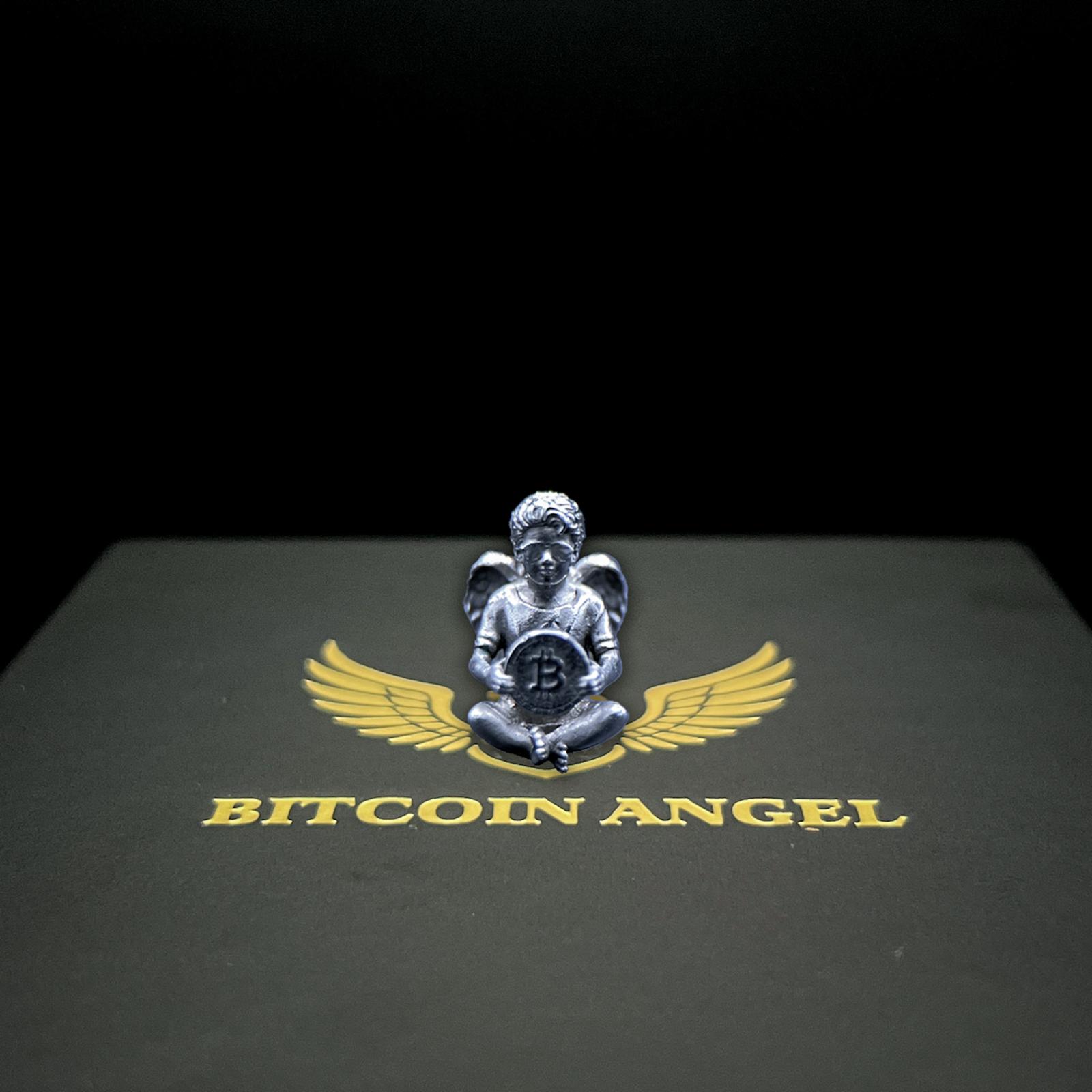 Metallic angel figurine with wings holding a Bitcoin symbol on a black background with 'Bitcoin Angel' text.