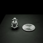 Small silver Bitcoin Angel figure with a coin on a dark surface